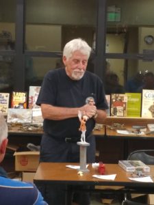 Jerry Jackson discussing his fairy figure and model railroad engine.